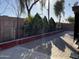 Stone paved backyard showcasing desert landscaping with block fence and various trees at 7551 W Pasadena Ave, Glendale, AZ 85303