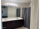 Bathroom featuring double sinks, vanity and shower with gray curtain at 7551 W Pasadena Ave, Glendale, AZ 85303