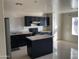 Modern kitchen with dark cabinetry, stainless steel appliances, and a central island at 7551 W Pasadena Ave, Glendale, AZ 85303