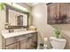 Bathroom with dark vanity, marble countertop, decorative mirror and cabinet at 8037 W Sweetwater Ave, Peoria, AZ 85381