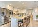 Modern kitchen featuring stainless steel appliances, granite countertops, a large island with seating, and custom white cabinets at 8037 W Sweetwater Ave, Peoria, AZ 85381