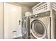 Practical laundry room featuring modern washer and dryer units with storage at 8037 W Sweetwater Ave, Peoria, AZ 85381