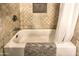 Bathroom tub and tiled shower with a decorative tile accent at 8037 W Sweetwater Ave, Peoria, AZ 85381