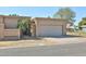 Tan home with a two-car garage, well-maintained yard, and a security gate at 8151 E Del Joya Dr, Scottsdale, AZ 85258