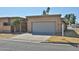 Beige single-story home showcasing a large, two-car garage and well-maintained lawn at 8151 E Del Joya Dr, Scottsdale, AZ 85258