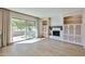 Bright living room with a brick fireplace, built-in shelving, and sliding glass doors at 8151 E Del Joya Dr, Scottsdale, AZ 85258