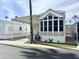 Charming manufactured home featuring covered parking, inviting front porch and desert landscaping at 944 S Nickel Dr, Apache Junction, AZ 85119