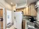 View of the kitchen area with light wood cabinets and a large white refrigerator, accessing exterior door at 944 S Nickel Dr, Apache Junction, AZ 85119