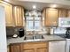 A functional kitchen features granite counters, double basin sink, stainless steel appliances and ample wood cabinets at 944 S Nickel Dr, Apache Junction, AZ 85119