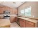 Bright kitchen features wood cabinets, stainless steel appliances, and a window over the sink at 11718 N 152Nd Dr, Surprise, AZ 85379