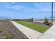 Community walkway featuring a wide concrete path bordered by desert landscaping and a low wall at 1317 S Vista Ave, Florence, AZ 85132