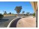 Paver patio overlooks the lush green golf course and blue sky at 13443 W Gable Hill Dr, Sun City West, AZ 85375