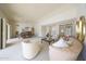 Bright living room showcases neutral decor and flows into the dining area with a large table at 13443 W Gable Hill Dr, Sun City West, AZ 85375