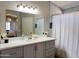 Bathroom featuring a shower with tiled walls, mirror, and white sink vanity with modern faucet at 1624 W Minton St, Phoenix, AZ 85041