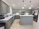 Updated kitchen featuring gray cabinetry, quartz counters, stainless appliances, and subway tile backsplash at 1624 W Minton St, Phoenix, AZ 85041