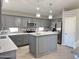 Stylish kitchen with gray cabinets, stainless steel appliances, a large island, and bright lighting at 1624 W Minton St, Phoenix, AZ 85041