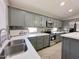 Beautiful kitchen boasts gray cabinetry, quartz countertops, stainless appliances, and tile backsplash at 1624 W Minton St, Phoenix, AZ 85041
