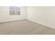 Neutral carpeted bedroom with a window offering natural light and bright white walls at 17426 W Eva St, Waddell, AZ 85355