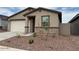 Single-story home featuring a two-car garage and a low-maintenance desert landscape at 17426 W Eva St, Waddell, AZ 85355