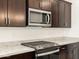 A close-up of a kitchen showcasing stainless steel appliances, granite counters and dark cabinetry at 17426 W Eva St, Waddell, AZ 85355