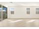 Spacious living room with tile floors, multiple windows, and a sliding glass door to the patio at 17426 W Eva St, Waddell, AZ 85355