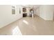 Bright, open living room with tile floors flows into a modern kitchen, illuminated by natural light at 17426 W Eva St, Waddell, AZ 85355