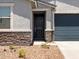 Charming home featuring a black front door, stone accents, and landscaped front yard at 17434 W Eva St, Waddell, AZ 85355