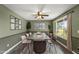 Spacious dining room with olive green walls, modern decor, large windows, and an elegant ceiling fan at 18223 N 20Th Pkwy, Phoenix, AZ 85023