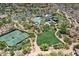 Stunning aerial view of community amenities featuring a pool, tennis courts, and manicured green spaces at 18650 N Thompson Peak Pkwy # 1028, Scottsdale, AZ 85255