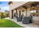 Relaxing outdoor patio with comfortable seating, ceiling fan, manicured lawn, and lush landscaping at 18650 N Thompson Peak Pkwy # 1028, Scottsdale, AZ 85255