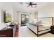 Bright main bedroom features a ceiling fan, a king bed, a dresser, and sliding glass doors to backyard at 18650 N Thompson Peak Pkwy # 1028, Scottsdale, AZ 85255