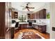 Spacious home office with custom built-ins, dual workstations, hardwood floors, and abundant natural light at 18650 N Thompson Peak Pkwy # 1028, Scottsdale, AZ 85255