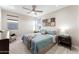 Unwind in this comfortable bedroom featuring a ceiling fan, a queen-sized bed, and neutral color tones at 20921 E Carriage Way, Queen Creek, AZ 85142