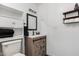 Bathroom featuring modern vanity with stylish mirror and rustic wood-look cabinet at 211 4Th W Ave, Buckeye, AZ 85326