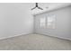 Bright empty bedroom featuring plush carpet, ceiling fan, and two shuttered windows at 23161 E Mockingbird Dr, Queen Creek, AZ 85142