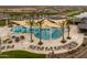 Overhead shot of a community pool with shade structures, palm trees, and plenty of lounge chairs at 23161 E Mockingbird Dr, Queen Creek, AZ 85142