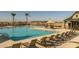 Large community pool with plenty of lounge chairs, shade structures, and palm trees at 23161 E Mockingbird Dr, Queen Creek, AZ 85142