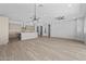 Open-concept living area with wood floors, modern lighting, and open access to a kitchen with center island at 23161 E Mockingbird Dr, Queen Creek, AZ 85142
