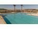 Beautiful pool with clear blue water, surrounded by palm trees and comfortable lounge chairs at 23161 E Mockingbird Dr, Queen Creek, AZ 85142
