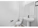 Clean powder room featuring a sleek pedestal sink, toilet, and modern fixtures at 23161 E Mockingbird Dr, Queen Creek, AZ 85142