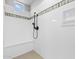 Modern walk-in shower with a bench and black hardware, enhanced by a decorative tile border at 23161 E Mockingbird Dr, Queen Creek, AZ 85142