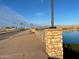 Scenic street view with walkway, lake, and mountain views in a well-maintained community at 23161 E Mockingbird Dr, Queen Creek, AZ 85142