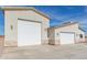 Three-car garage home exterior with stone veneer and a large concrete driveway under a sunny blue sky at 24032 W Redbird Rd, Wittmann, AZ 85361