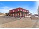 A striking red barn-style building with a covered porch and lush desert landscape at 27194 N Bear Paw Pass, San Tan Valley, AZ 85144