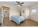 Comfortable bedroom with wood-look tile floors, ceiling fan, and a convenient adjacent doorway at 27194 N Bear Paw Pass, San Tan Valley, AZ 85144