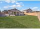 Spacious backyard featuring a well-manicured lawn, a covered patio, and a block wall fence for privacy at 29219 N Red Finch Dr, San Tan Valley, AZ 85143