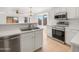 Well-lit kitchen with stainless steel appliances, white cabinets, and a convenient breakfast bar area at 29219 N Red Finch Dr, San Tan Valley, AZ 85143