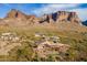 Aerial view of the home surrounded by desert landscape, other houses, and a mountain backdrop at 3086 N Herrala Way, Apache Junction, AZ 85119