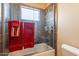 Bathroom shower and tub combination with dark tile and red towels hanging on the glass door at 3086 N Herrala Way, Apache Junction, AZ 85119