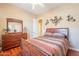 Comfortable bedroom with wood floors, dresser, and decorative metal butterfly wall art at 3086 N Herrala Way, Apache Junction, AZ 85119